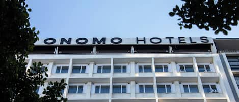 A hotel building with the name 'ONOMO HOTELS' on the facade.