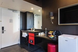 A modern kitchen with a built-in refrigerator, a coffee maker, and a sink.