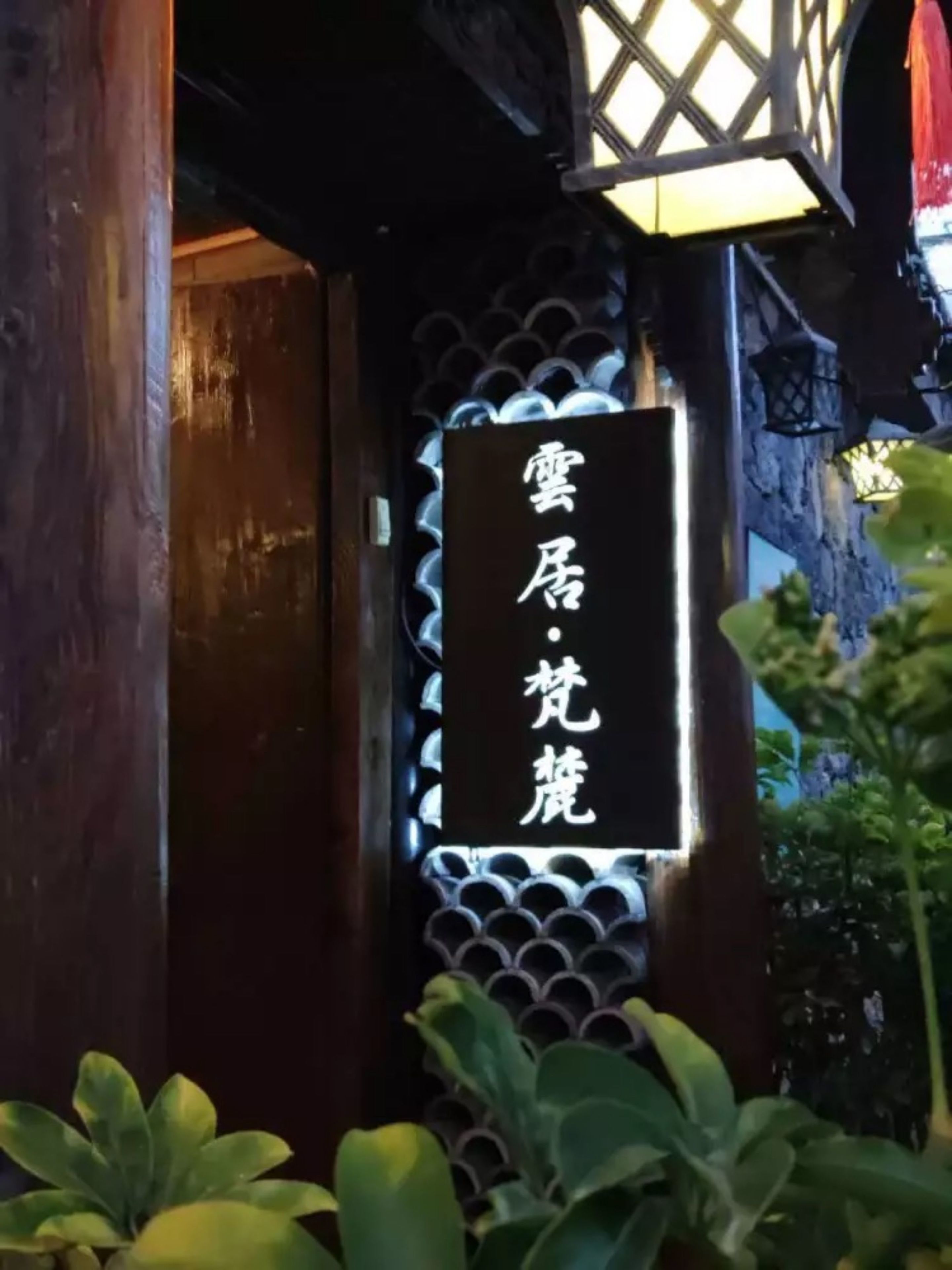 A traditional wooden structure with a signboard displaying Chinese characters.
