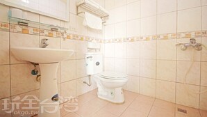A bathroom with a white sink, toilet, and shower.