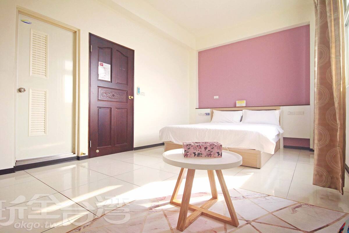 Una habitación de hotel con una cama, una mesa redonda y una puerta.