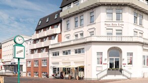 A multi-story building with a prominent entrance and a sign reading "Haus Rote Erde". - BSW Inselhotel Rote Erde Borkum (Borkum)