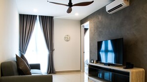A modern living room with a sofa, TV, and ceiling fan. - H2O Residences by Victoria Home (Petaling Jaya)
