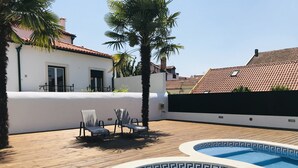 A swimming pool with two lounge chairs and a palm tree. - O Paço - Exclusive Accommodation (Tomar)
