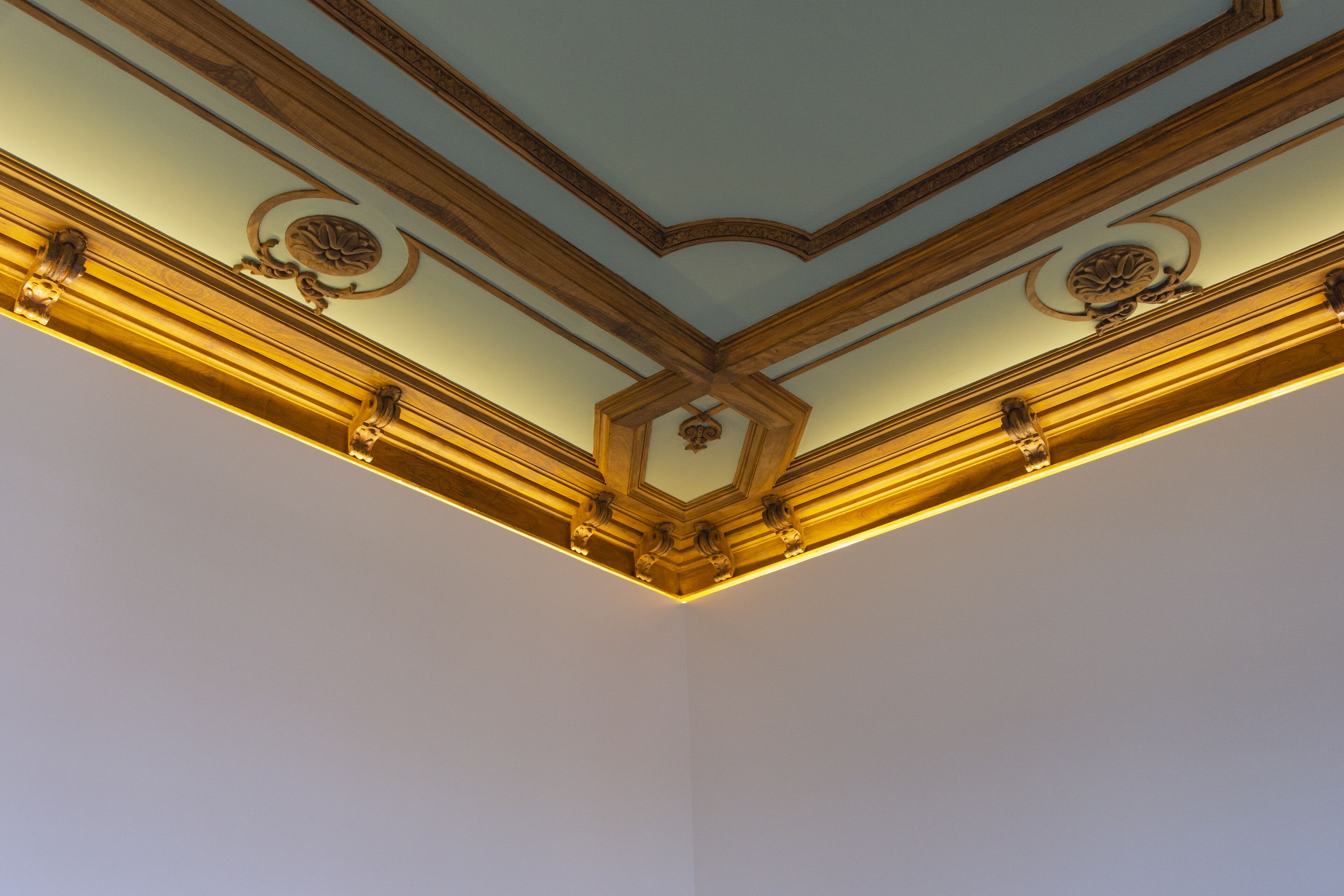 A ceiling with ornate wood trim and decorative moldings.