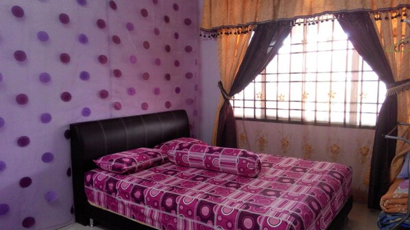 A bedroom with a bed, a window with curtains, and a wall with a polka dot pattern. - Zaida Homestay Changlun (Changlun)