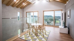 A modern kitchen with a central island, large windows, and a view of the outdoors. - Oakra Resort (Seogwipo)