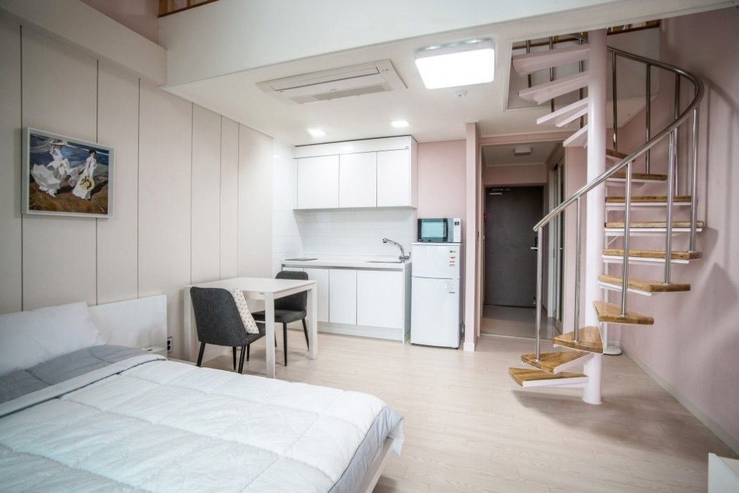 Une chambre moderne équipée d’un lit, d’un bureau et d’une kitchenette.