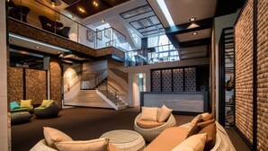 A spacious lobby with a staircase, wicker seating, and a modern design. - Oakra Resort (Seogwipo)