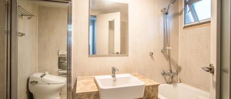 Un baño moderno con inodoro, lavamanos y bañera.
