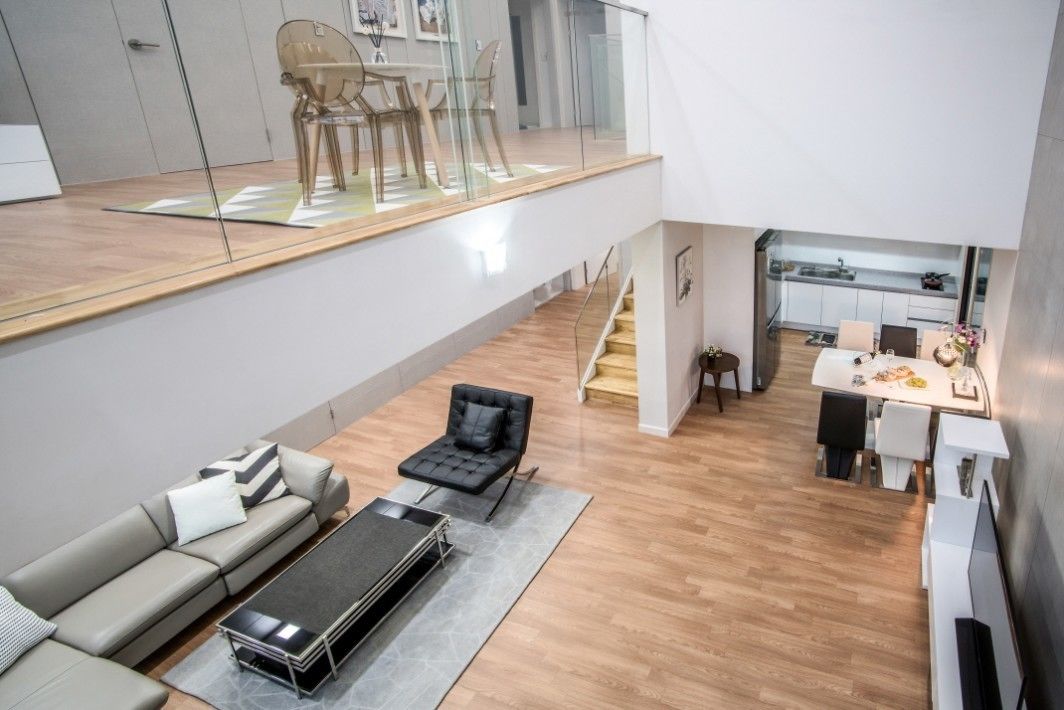 A modern apartment with a loft-style living area, a dining space, and a kitchen.