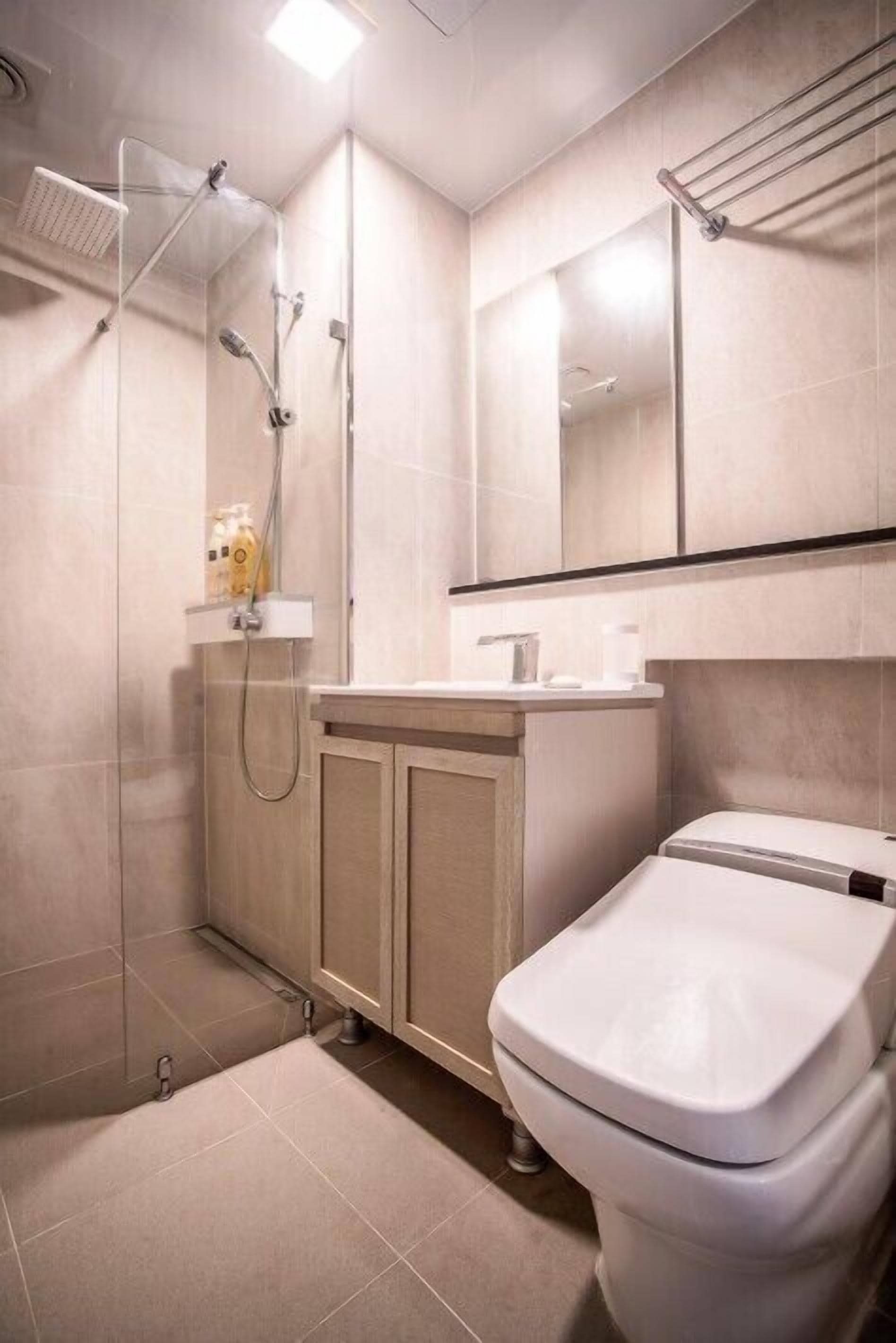 Une salle de bain moderne équipée d’une douche, de toilettes et d’un meuble-lavabo.