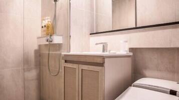 Une salle de bain moderne équipée d’une douche, de toilettes et d’un meuble-lavabo.