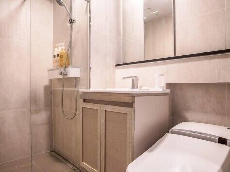 Une salle de bain moderne équipée d’une douche, de toilettes et d’un meuble-lavabo.
