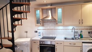 A modern kitchen with a built-in oven, a Bosch washing machine, and a compact dishwasher. - Lovely Family House in Sidcup (Sidcup)