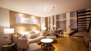 A modern living room with a sofa, armchairs, a coffee table, and a staircase. - Ningxia Dejilinka Hotel (Yinchuan)