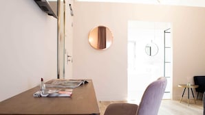 Une chambre moderne avec un bureau en bois, un miroir rond et une chaise.