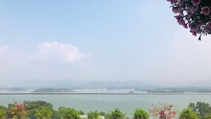 A terrace with potted plants overlooking a body of water and distant mountains. - Lakeside Dailai Hotel (Xuan Hoa)