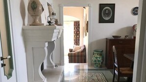 A hallway with a patterned floor, a staircase, and a dining area with a table and chairs. - Casa del Grifone (Carovigno)