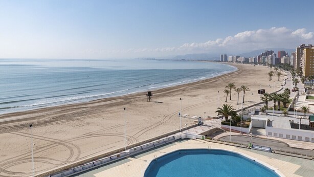 A beach with a swimming pool, palm trees, and a lifeguard tower. - PRADO, A-7º-72 PK INT 83 (Cullera)