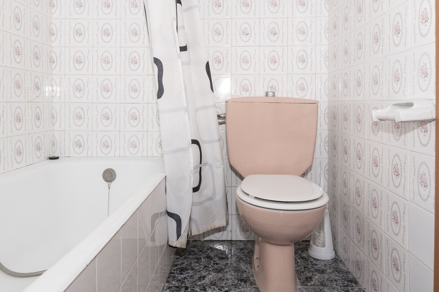 A bathroom with a toilet, a bathtub, and a shower curtain.