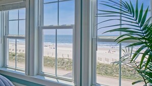Una habitación con amplios ventanales con vistas a la playa.
