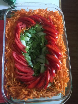 A glass dish with shredded carrots, red bell peppers, and chopped onions. - Odjidja Royal Palace Hotel (Taifa)