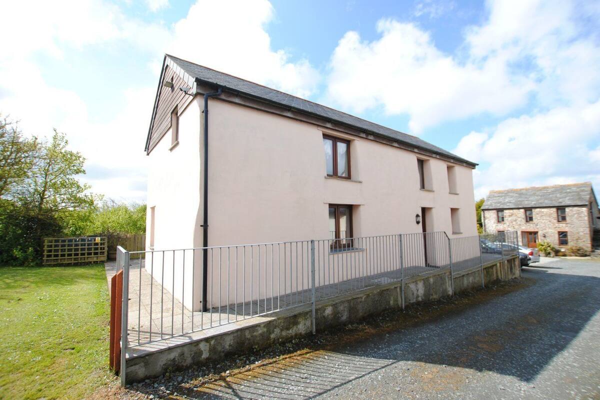 Un bâtiment à deux étages, doté d’un toit plat et d’un petit porche.
