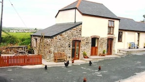 A two-story house with a stone facade and a sloped roof.