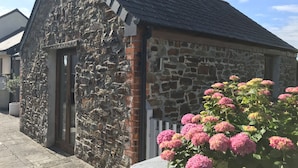 A stone building with a sloped roof and a door.