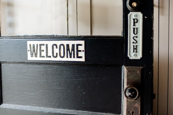A door with a 'WELCOME' sign and a 'PUSH' sign. - Studio 555 (Granville)