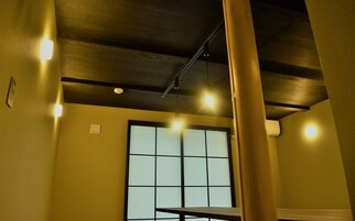Una habitación con un gran ventanal, luces empotradas en el techo y un equipo de aire acondicionado visible.