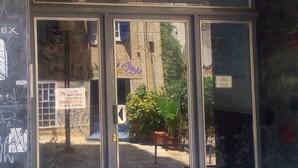 A building entrance with a glass door and a number 9 sign above it. - Dervenion-Athens Cozy Apartment (Athens)