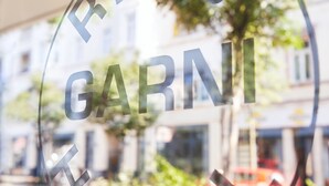 A hotel logo with the name "RING GARNI HOTEL" on a glass window. - Ring Hotel (Wiesbaden)