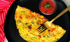 A plate with a slice of omelette and a small bowl of sauce. - The Hideout Agra Homestay (Agra)