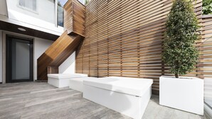 Ein modernes Interieur mit einer Wand aus Holzlatten, einer Treppe und weißer eingelassener Sitzgelegenheit.