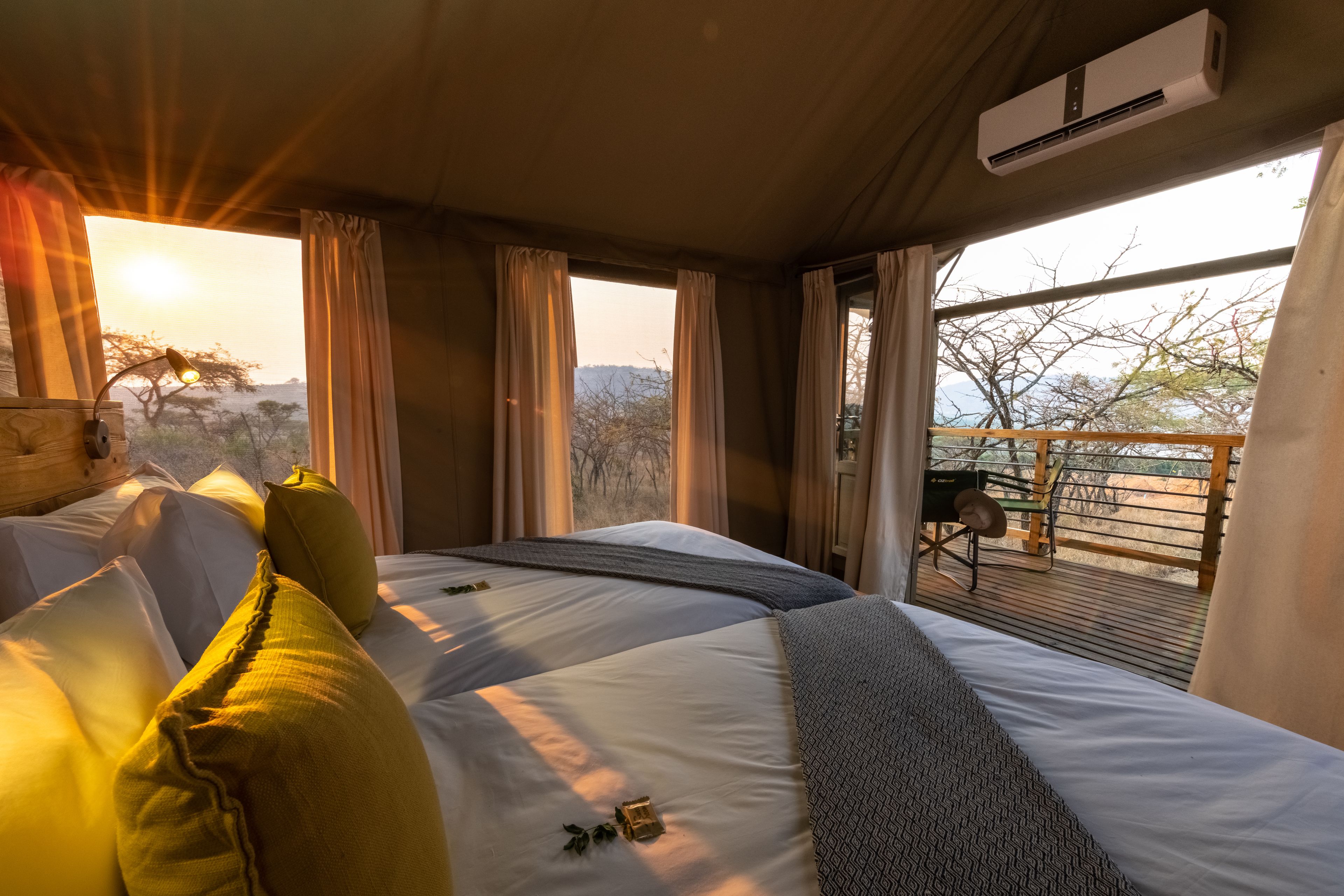 Une chambre avec un grand lit, une vue sur l’extérieur et un appareil de climatisation.