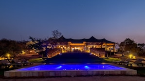 Ein Resort mit Pool, Außenbereich zum Sitzen und einem mehrstöckigen Gebäude mit Treppen.