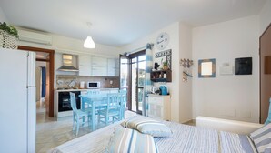 Un dormitorio con cama, almohadas y vistas a la cocina y comedor.