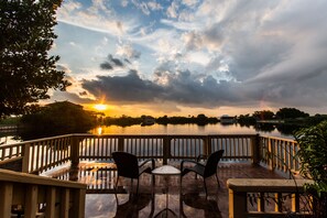 A terrace with a view of a lake and sunset. - Stunning Lake View Pool Villa with SPA and Heated Pool<br> (Cape Coral)