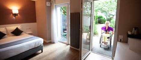 Une chambre d’hôtel moderne dotée d’un lit, d’une douche et donnant sur un jardin.