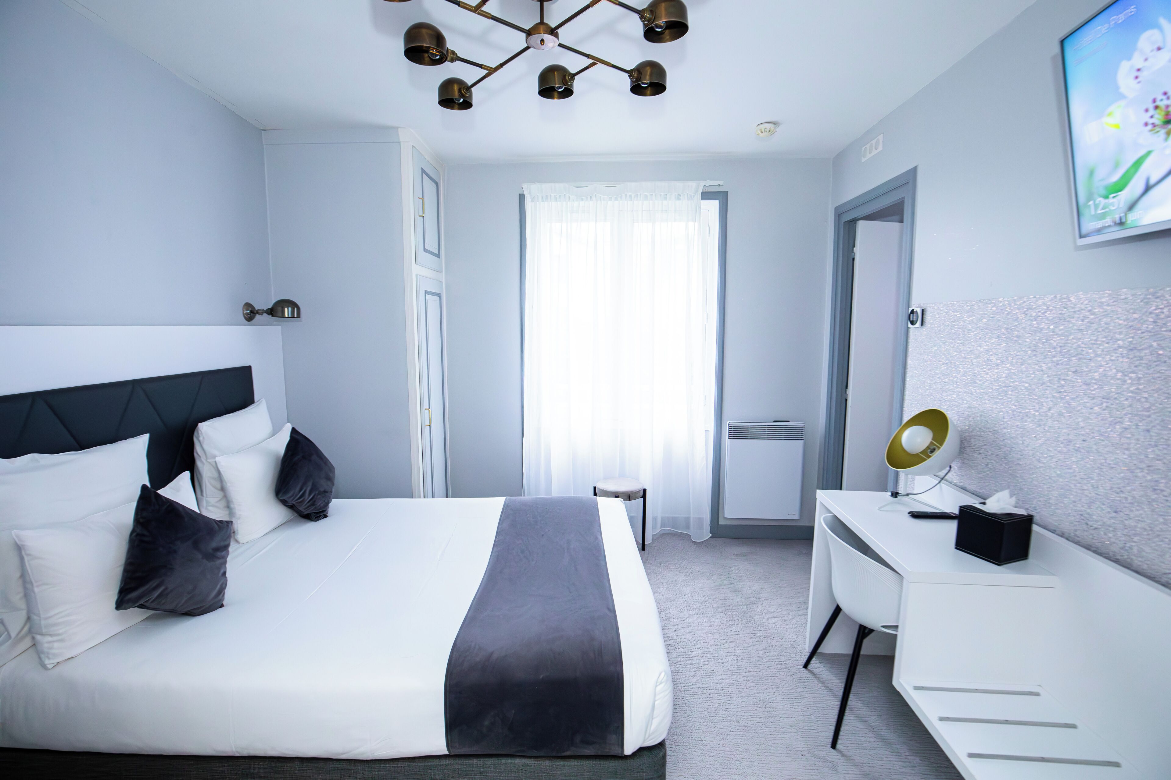 Une chambre d’hôtel moderne, dotée d’un grand lit, d’un bureau et d’une chaise.