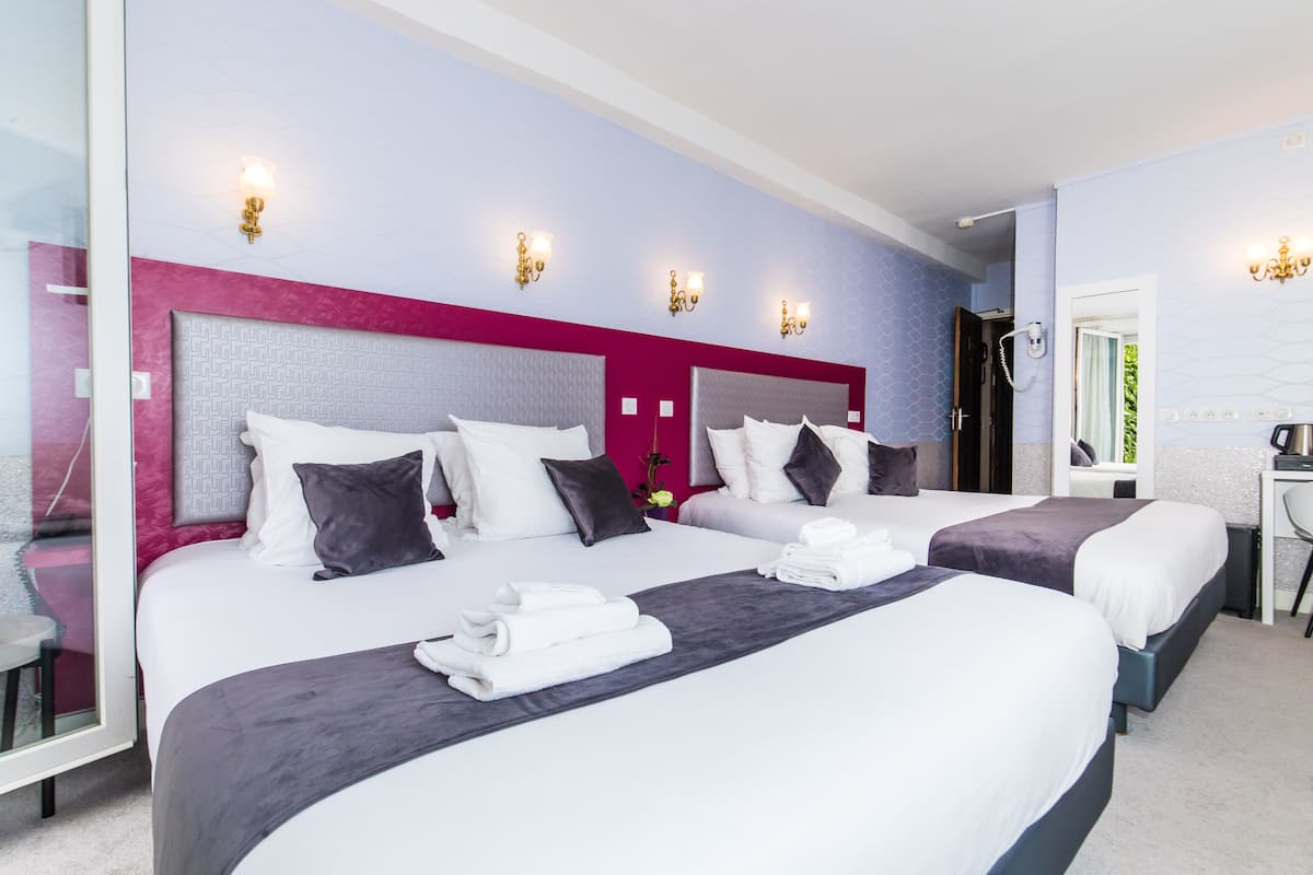 Une chambre d’hôtel avec deux lits, un bureau et une chaise.