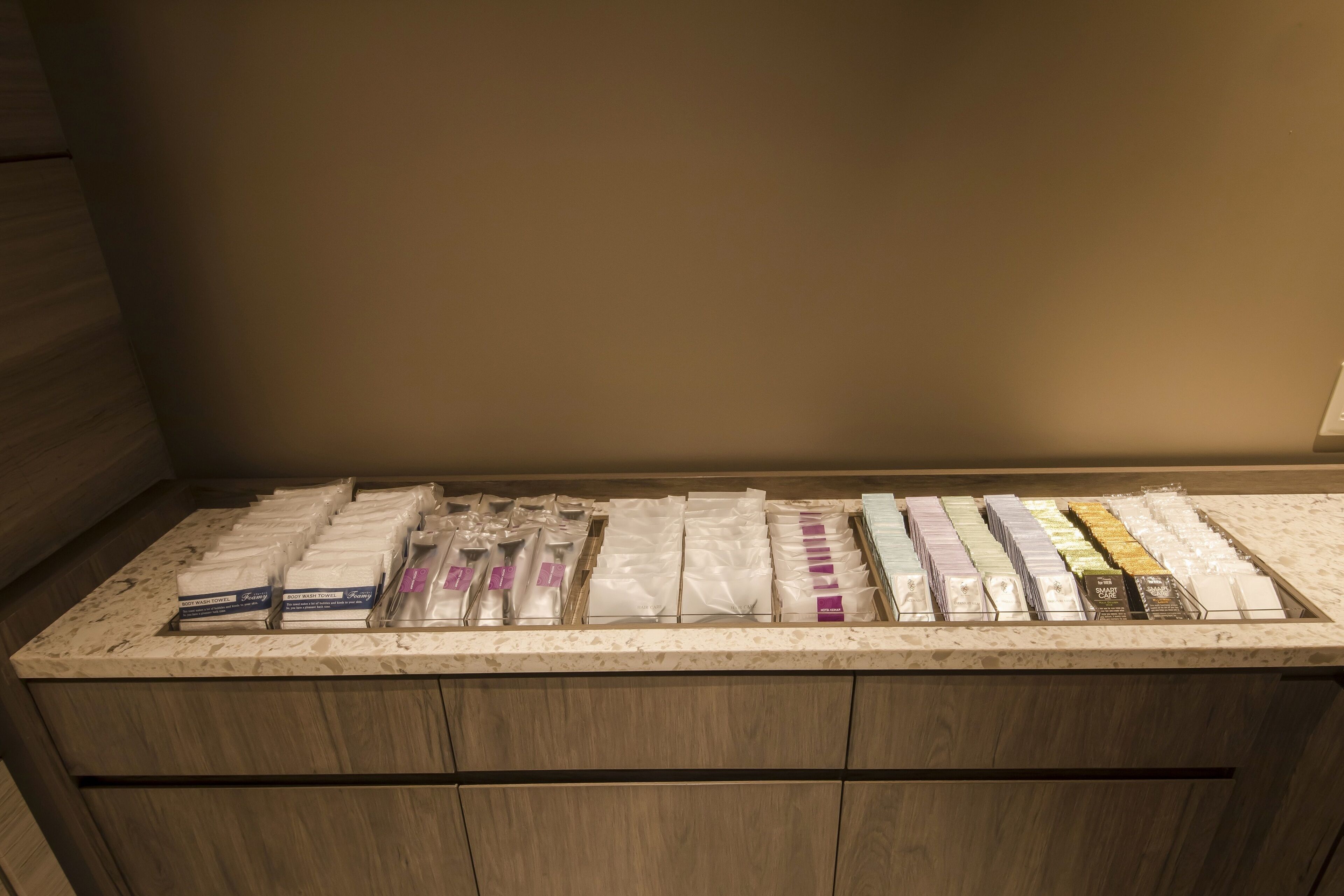 A display of various packaged items on a wooden counter in a room with wooden walls.