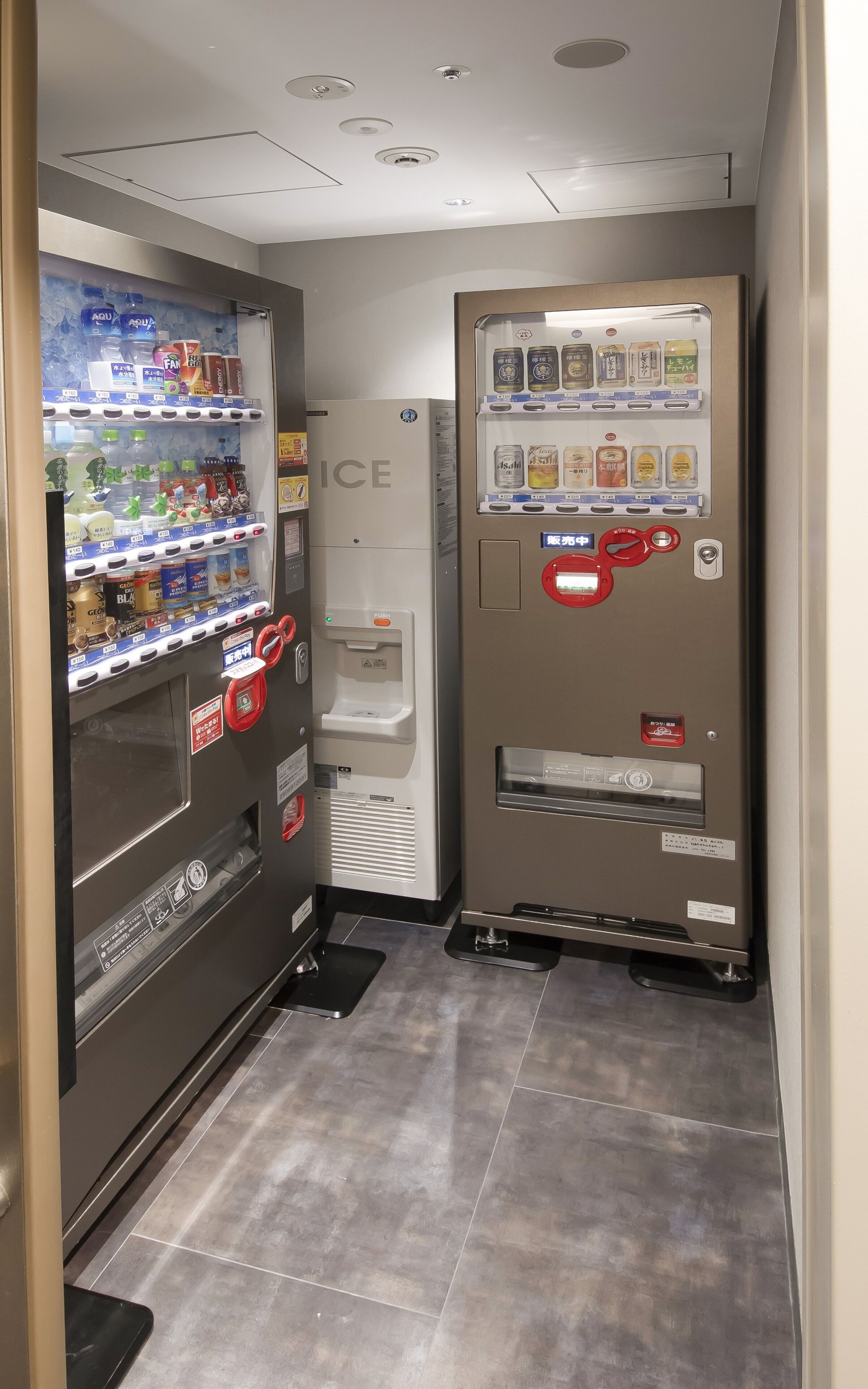 Zona de máquinas expendedoras con dispensador de agua y variedad de bebidas y aperitivos.