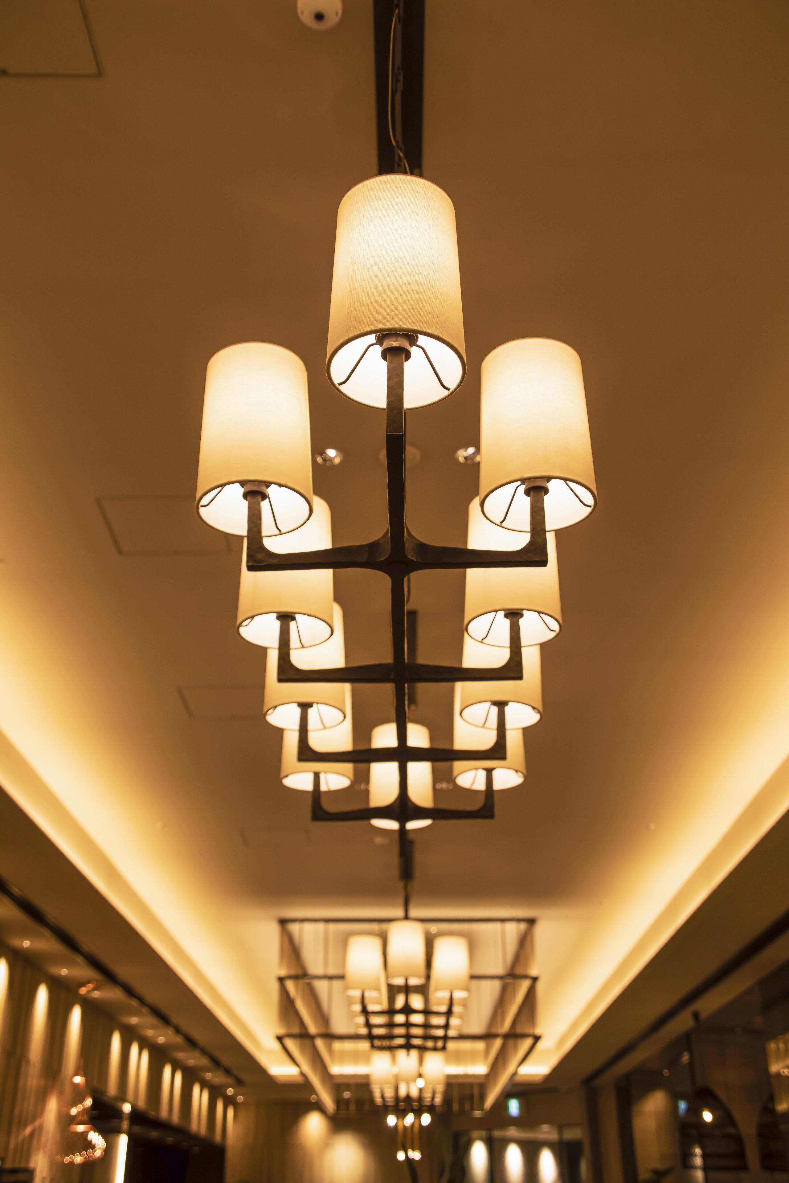 A chandelier with multiple light fixtures in a hallway.