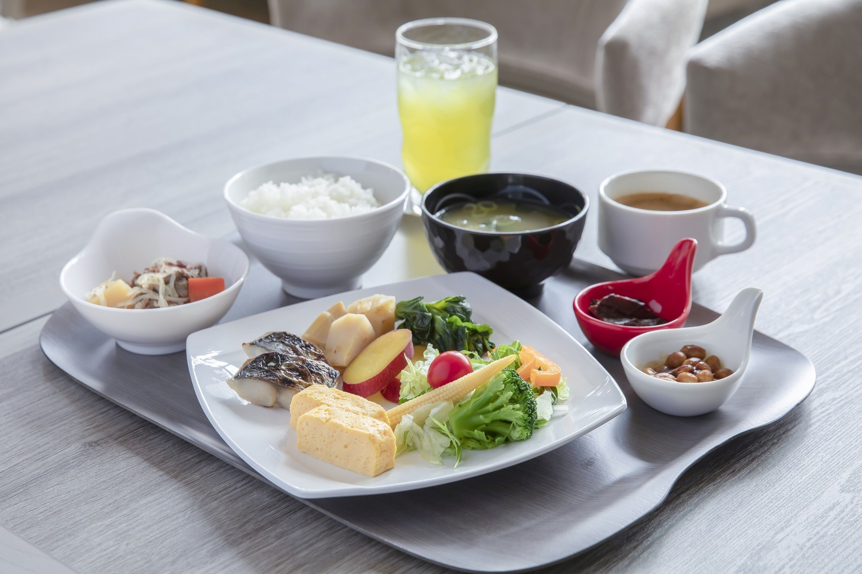 Bandeja de comida con diferentes platos, como arroz, sopa y verduras.