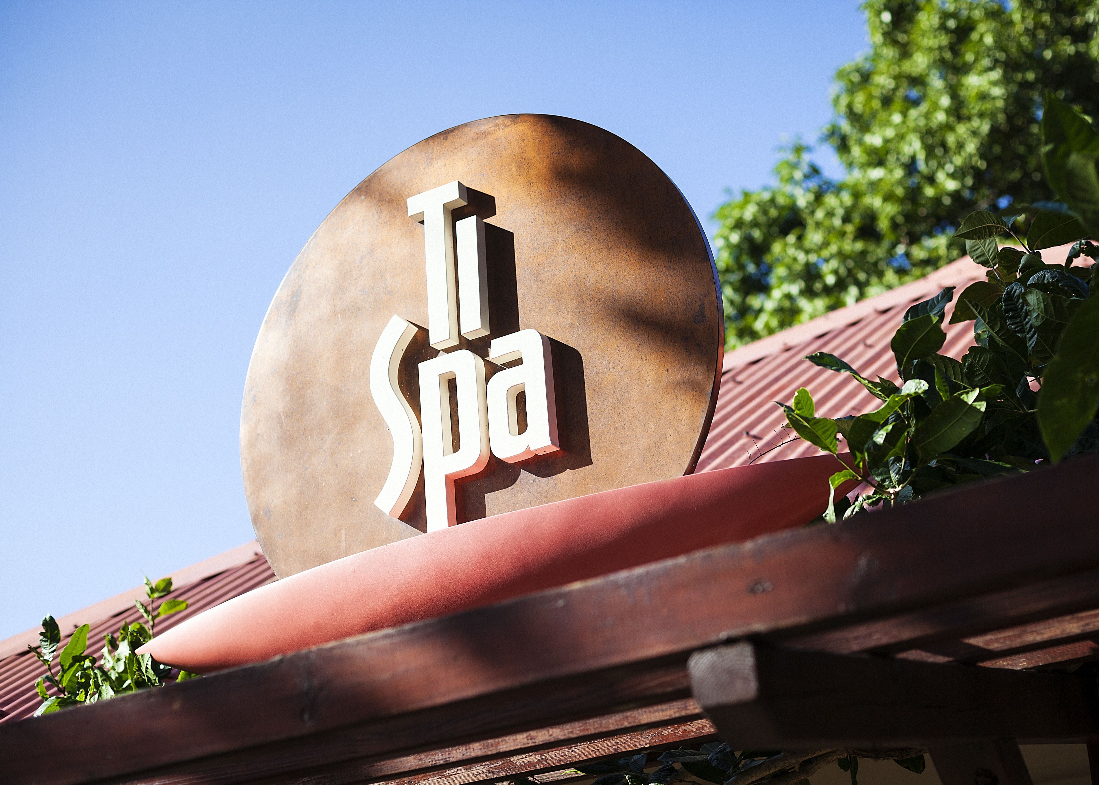 A sign with the text "Spa" on a curved metal surface.