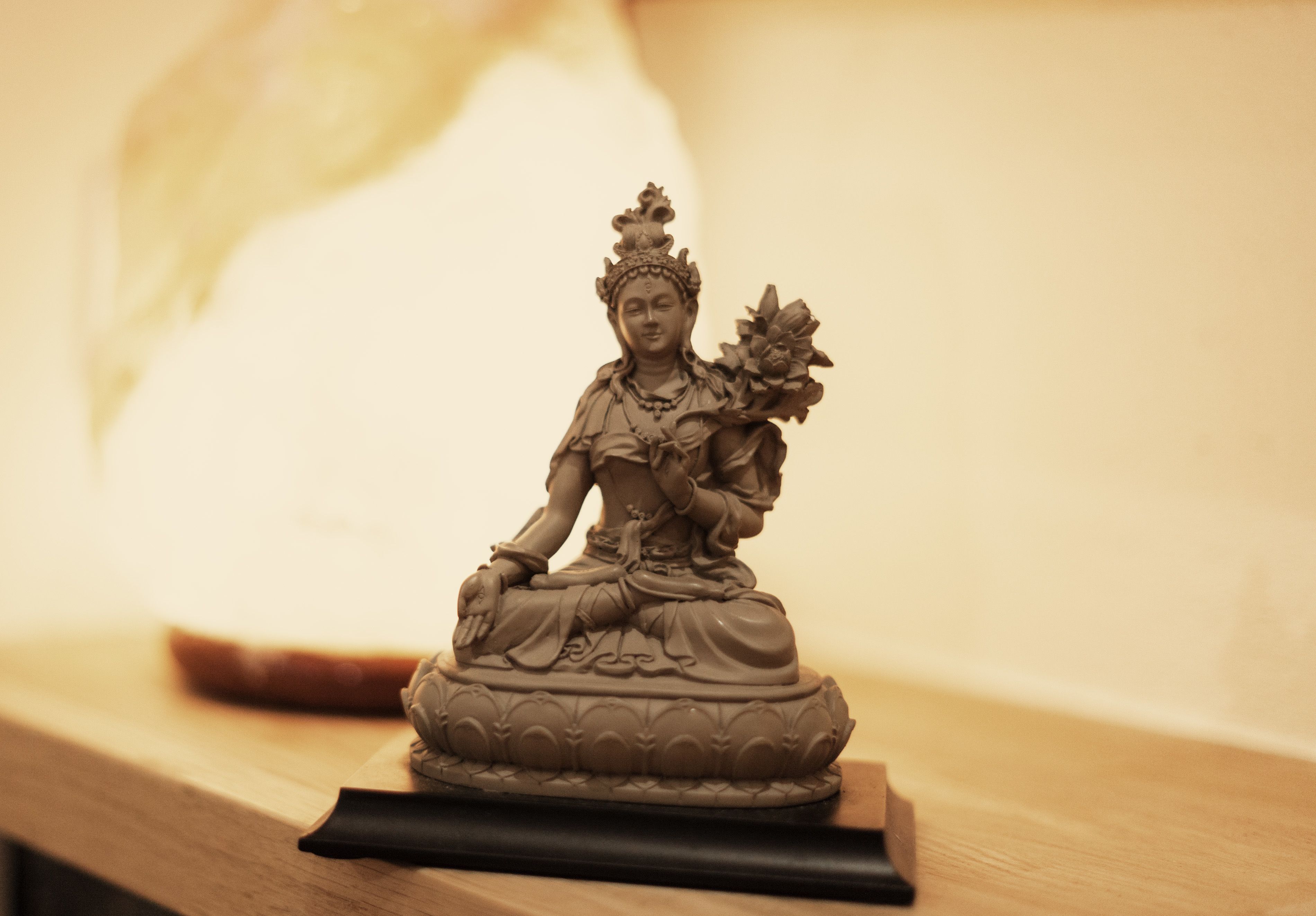 Una statua di una figura seduta su un piedistallo.