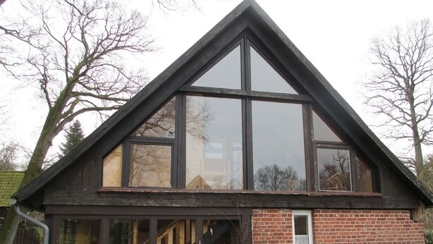 A modern house with a steeply pitched roof, large windows, and a brick exterior. - Ennenhof (Schneverdingen)